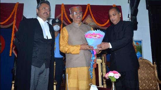 Chief minister Jai Ram Thakur felicitating Rajendra Arlekar (centre) after he was sworn in as the governor of Himachal Pradesh as acting chief justice of the high court, justice Ravi Malimath, looks on in Shimla on Tuesday. (HT Photo)