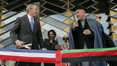 In this March 1, 2006 photo, US President George W Bush (left) and Afghan President Hamid Karzai get ready to cut a ribbon to officially open the US Embassy in Kabul, Afghanistan. (AP)