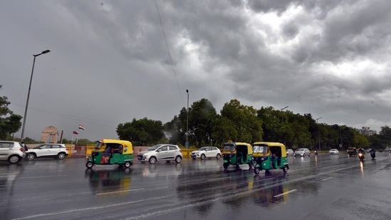 Commuters out in the rain near India Gate in New Delhi on July 13. Beginning with a short spell in the morning, the showers brought not just respite from heat, but also an end to a cycle of incorrect predictions about the arrival of the monsoon in the capital for IMD.(Arvind Yadav / HT Photo)