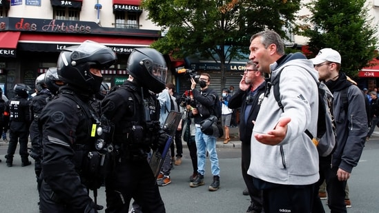 A demonstrator argues with police officers during a protest against the new measures announced by French President Emmanuel Macron to fight the coronavirus disease (Covid-19) outbreak, in Paris, France.(REUTERS)