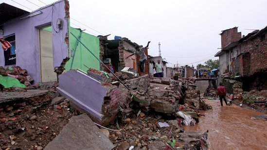 Local residents inspecting the debris of their houses after they were damaged by flash floods caused due to heavy monsoon rains on the outskirts of Jammu on July 12.(Rakesh Bakshi / AFP)