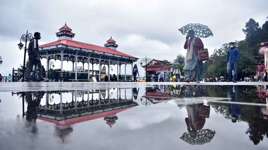 People out with umbrellas after a spell of rain at Ridge in Shimla on July 12. The influx of tourists to the hilly, northern states over recent weeks has already caused alarm due to Covid-19 concerns. (Deepak Sansta / HT Photo)