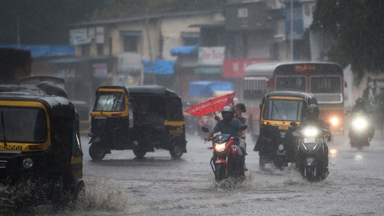 Commuters making their way across a waterlogged road during heavy dowpour at Bhandup, in Mumbai on June 12. In the initial weeks, the monsoon rains touched down on the Indian coast on June 3, three days later than usual. By June 18, the monsoon had covered all of Maharashtra, central India, east India and even parts of UP, a week ahead of its usual pace. The monsoon had appeared set to break several previous coverage records, particularly at the pace it was barrelling towards Delhi.(Pratik Chorge / HT Photo)