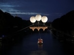A view of an art installation by French artist Olivier Grossetete titled "The Farnese Bridge", showing a Michelangelo-inspired cardboard bridge floating above the Tiber river, suspended by three balloons, in Rome, Italy. 