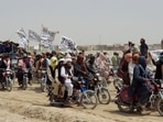 People on vehicles, holding Islamic Emirate of Afghanistan flags, gather near the Friendship Gate crossing point in the Pakistan-Afghanistan border town of Chaman, Pakistan. 