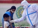 A health worker collects a nasal swab sample from a boy for Covid-19 testing at the urban primary health centre, in Bhubaneswar.(HT Photo) A health worker collects a nasal swab sample from a boy for Covid-19 testing at the urban primary health centre, in Bhubaneswar.(HT Photo)