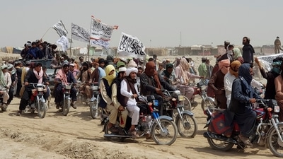 People on vehicles, holding Islamic Emirate of Afghanistan flags, gather near the Friendship Gate crossing point in the Pakistan-Afghanistan border town of Chaman, Pakistan. (REUTERS)