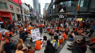 People occupying space at Yonge and Dundas street, after the discovery of hundreds of remains of children at former indigenous residential schools, on Canada Day in Toronto, Ontario, on July 1, 2021. (REUTERS) People occupying space at Yonge and Dundas street, after the discovery of hundreds of remains of children at former indigenous residential schools, on Canada Day in Toronto, Ontario, on July 1, 2021. (REUTERS)