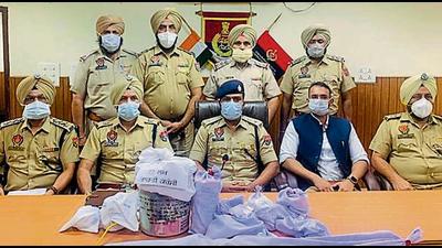 Police with the recovered weapons and drugs in Tarn Taran. Police with the recovered weapons and drugs in Tarn Taran.