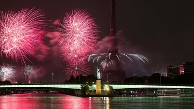 As part of the annual Bastille Day celebration, fireworks exploded above the Eiffel Tower, replica of the Statue of Liberty and the Seine River on July 14. (Photo by JOEL SAGET/AFP)