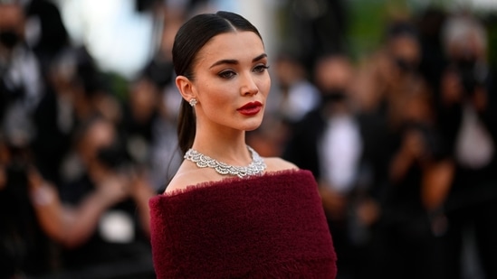 Amy sported bloody coloured nails, lipstick, a heavy contour and dramatic eyeliner to complete her stunning red carpet look.(AFP)