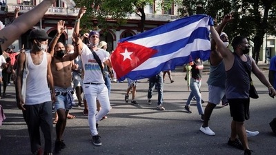 People hold Cuba's national flag during protests against and in support of the government, amidst the coronavirus disease outbreak in Havana, Cuba. (Reuters)