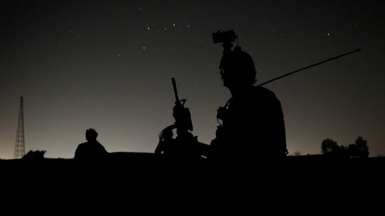 Members of the Afghan Special Forces keep a watch as others search houses in a village during a combat mission against Taliban, in Kandahar province, Afghanistan on July 12. The Taliban have captured key districts near Kandahar over recent days and engaged Afghan forces in several police districts on the outskirts of the capital.(Danish Siddiqui / REUTERS)
