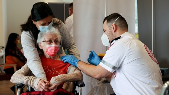 An elderly woman receives a booster shot of her vaccination against Covid-19 at an assisted living facility, in Netanya, Israel.(Reuters)