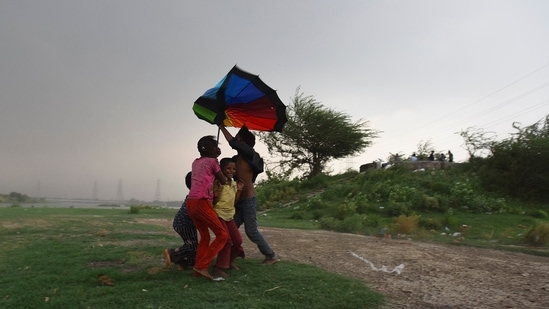 Children out during heavy rain at Yamuna River Bank in New Delhi(Raj K Raj / Hindustan Times)
