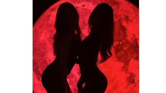 Suhana poses with a friend against a blood moon setup. The mini dress worn by Suhana has a signature double layered fabric, long mesh sleeves and an angled square neckline. The Lace Me In mini is priced on the brand's website at £50 which is approximately <span class=