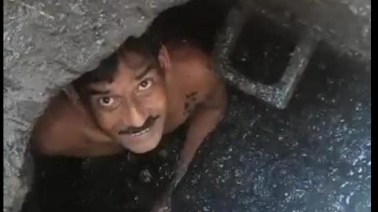 A sewerman cleaning a manhole in Ludhiana’s Jugiana area on Friday. (HT Photo)