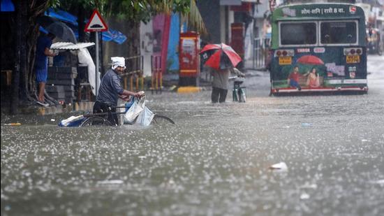 People wade through a waterlogged road after heavy rainfall in Mumbai on Friday, July 16. (Reuters)