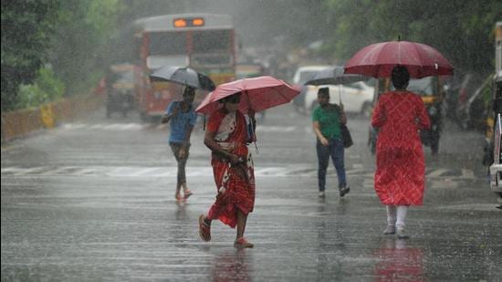 People walk amid heavy downpour in Kandivali, Mumbai. (HT PHOTO)