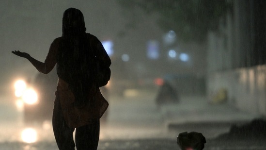 A women walk along a street during a heavy rainfall in Chennai. (AFP image) (AFP)