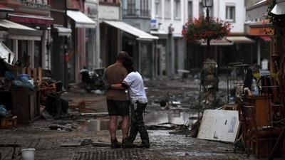 A couple hug as they stand amongst debris left by flood waters in a street in the town of Bad Neuenahr-Ahrweiler, Germany on July 15. In Germany's worst-hit regions of North Rhine-Westphalia and Rhineland-Palatinate, residents who fled the deluge are gradually returning to their homes and scenes of desolation, AFP reported. (Christof Stache / AFP)