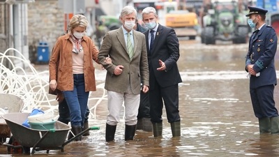 King Philippe of Belgium (L) and Queen Mathilde of Belgium (2nd R) walk in a flooded street of Pepinster on July 16, during a visit to the city, where the situation remained critical after the heavy rainfall of the previous days. (Bruno Fahy / BELGA / AFP)