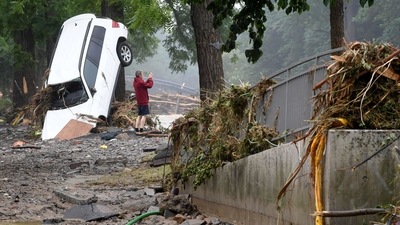 A man standing next to a destroyed car takes pictures of the devastated area after floods caused major damage in Bad Neuenahr-Ahrweiler, western Germany on July 16, The real scale of the disaster is only now becoming clear, with damaged buildings being assessed and efforts under way to restore gas, electricity and telephone services. (Christof Stache / AFP)