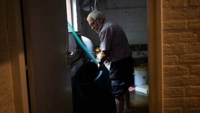 A resident pumps water out of his flooded basement in Brommelen. "When we have this heavy rainfall, then the atmosphere is almost like a sponge - you squeeze a sponge and the water flows out," said Johannes Quaas, professor of Theoretical Meteorology at Leipzig University.  (AP Photo/Bram Janssen)
