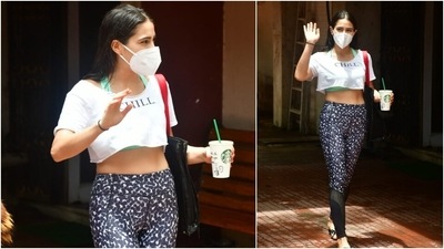 Sara Ali Khan wore a white slogan crop top that said 'Chill' over a green halter neck sports bra and animal print workout tights. The tights featured sheer details on the calves. (Varinder Chawla) Sara Ali Khan wore a white slogan crop top that said 'Chill' over a green halter neck sports bra and animal print workout tights. The tights featured sheer details on the calves. (Varinder Chawla)