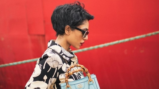 Photos: Sobhita Dhulipala poses for Gucci in pixie 4 In images clicked by the sea near ships against a vibrant red background, Sobhita was seen in the distance wearing all Gucci from head to toe. Sobhita wore a Poppy Flowers print jersey dress with botanical prints and patterns that signify Gucci's affinity for nature. (Instagram)