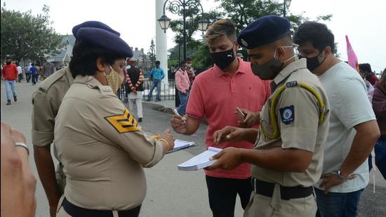 Cops issuing challans to people found violating Covid norms in Shimla on Saturday. (Deepak Sansta/HT)