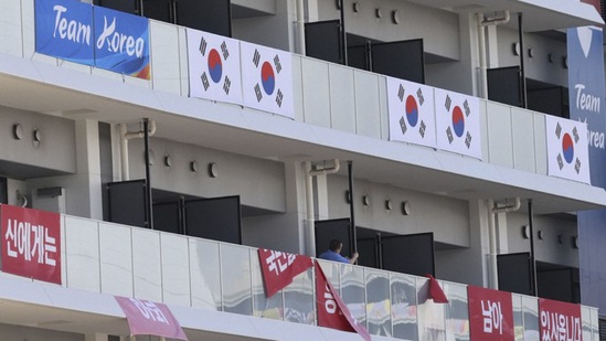 Banners with the words "I still have the support of 50 million Korean people," are removed from balconies at the the Olympic athletes' village. (AP)