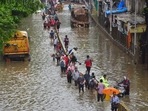 Commuters wade through a waterlogged street after heavy rain at Dadar in Mumbai on Sunday, Commuters wade through a waterlogged street after heavy rain at Dadar in Mumbai on Sunday,