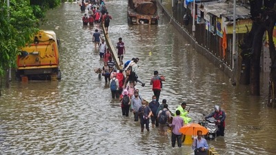 Commuters wade through a waterlogged street after heavy rain at Dadar in Mumbai on Sunday, (PTI) Commuters wade through a waterlogged street after heavy rain at Dadar in Mumbai on Sunday, (PTI)