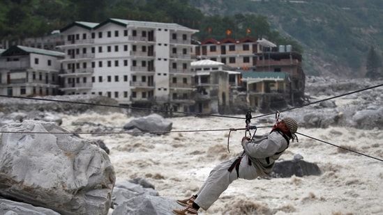 A man is pulled across to safety on a rope, as damaged buildings and the Alaknanda river are seen in the background in Uttarakhand.(Reuters/ File photo)
