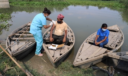 A health worker administers a vaccine for COVID-19 to a boatman on an island in the River Yamuna in New Delhi. (AP Photo) A health worker administers a vaccine for COVID-19 to a boatman on an island in the River Yamuna in New Delhi. (AP Photo)