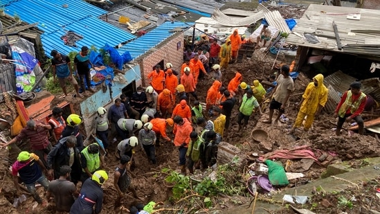 Rescuers look for survivors after a wall collapsed on several slums because of heavy rain in the Mahul area of Mumbai on July 18, At least 25 people have died in three suburbs due to houses collapsing after landslides triggered by heavy rain, Reuters reported.(Rajanish Kakade / AP)