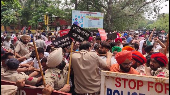 The protesting employees scuffle with police on Sunday.