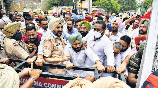 Protesters trying to jump barricades outside the residence of cabinet minister Bharat Bhushan Ashu in Ludhiana on Sunday. (Harsimar Pal Singh/HT)