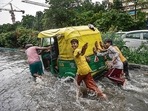 People push an autorickshaw through a waterlogged street following heavy rains, near ITO in New Delhi. (PTI Photo) People push an autorickshaw through a waterlogged street following heavy rains, near ITO in New Delhi. (PTI Photo)