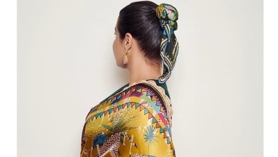 The 42-year old took to her Instagram feed and shared multiple images o herself wearing a printed black and yellow saree printed with elements of nature along with a sleeveless blouse, and a funky scarf tied around her bun to give it a fusion look that combined vintage with modern elements. (Instagram) The 42-year old took to her Instagram feed and shared multiple images o herself wearing a printed black and yellow saree printed with elements of nature along with a sleeveless blouse, and a funky scarf tied around her bun to give it a fusion look that combined vintage with modern elements. (Instagram)