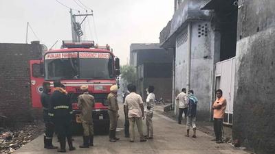 Firemen trying to douse the flames at the cardboard godown on Tejpur road in Ludhiana on Monday. (HT PHOTO)