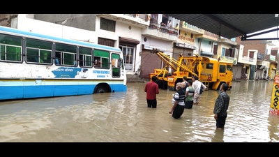 A crane pulling a Haryana Roadways bus on a waterlogged road following heavy downpour in Jind on Monday. (Manoj Dhaka/HT) A crane pulling a Haryana Roadways bus on a waterlogged road following heavy downpour in Jind on Monday. (Manoj Dhaka/HT)