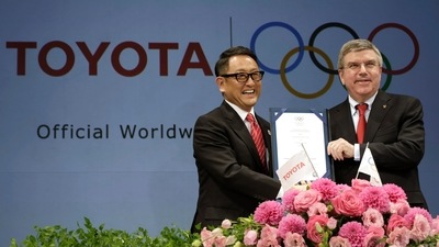 FILE - Toyota President and CEO Akio Toyoda, left, and IOC President Thomas Bach pose with a signed document during a press conference in Tokyo. (AP)