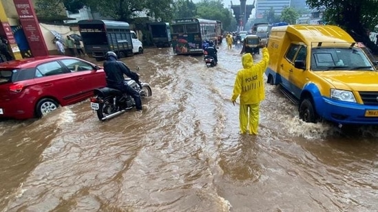 A policeman directs traffic in a water logged Mulund (HT Photo/Pratik Chorge)