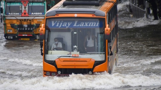 Vehicles commute through a waterlogged road after heavy rainfall, at Matunga, in Mumbai on Sunday. (ANI Photo)