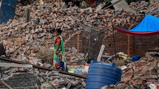 A woman loiters near the debris of her house after local authorities razed a settlement that was said to be in a forest land in Khori village at Faridabad. (AFP)