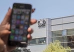 A woman uses her iPhone in front of the building housing the Israeli NSO group "Pegasus", in Herzliya, near Tel Aviv.