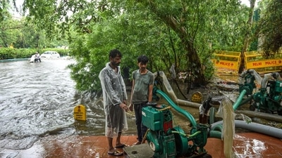 Municipal workers remove water from a waterlogged road after heavy rains, at Ring Road near ITO in New Delhi on Monday, July 19. (PTI) Municipal workers remove water from a waterlogged road after heavy rains, at Ring Road near ITO in New Delhi on Monday, July 19. (PTI)