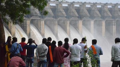 This photo taken on July 24, 2018 shows people watching water pour out of seven of 21 gates of the Bargi Dam that were opened after excess rain in Jabalpur in India's central Madhya Pradesh state. Bargi Dam on the Narmada River in Madhya Pradesh is one of the first completed dams along the waterway. / AFP PHOTO / - (AFP) This photo taken on July 24, 2018 shows people watching water pour out of seven of 21 gates of the Bargi Dam that were opened after excess rain in Jabalpur in India's central Madhya Pradesh state. Bargi Dam on the Narmada River in Madhya Pradesh is one of the first completed dams along the waterway. / AFP PHOTO / - (AFP)